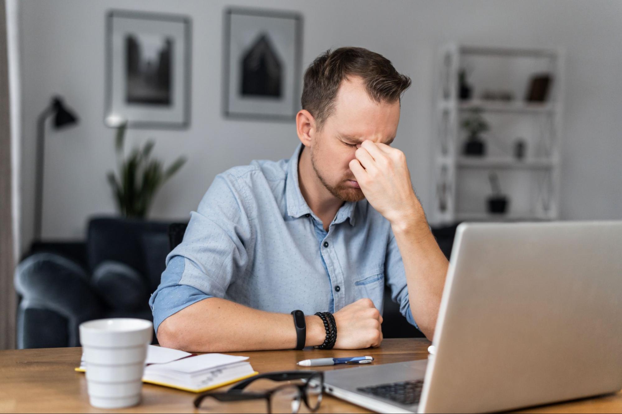 optimal blood glucose level for ketosis: stressed man holding the bridge of his nose