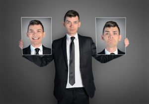 Business Man Holds Face of Him Smiling and Face of Him Frowning