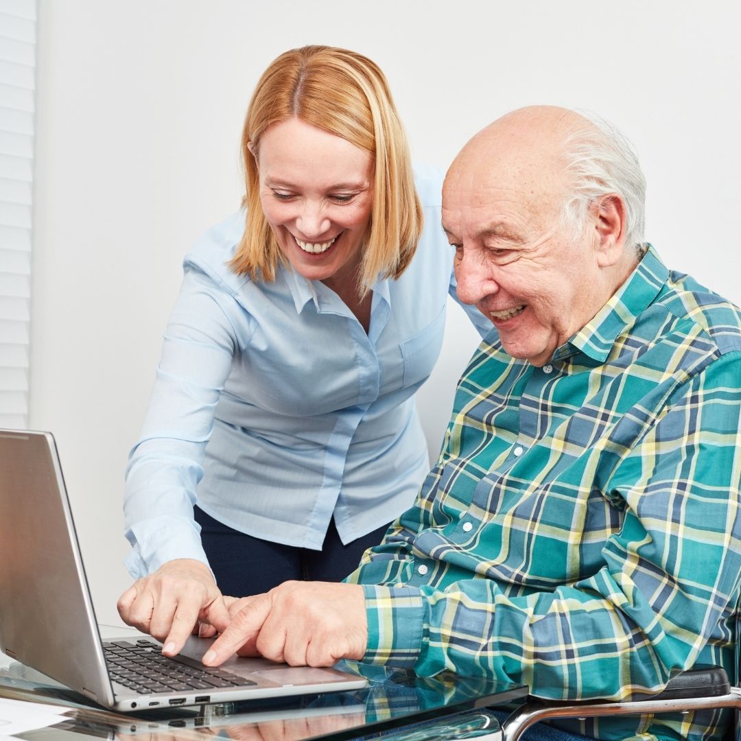woman helping man with computer