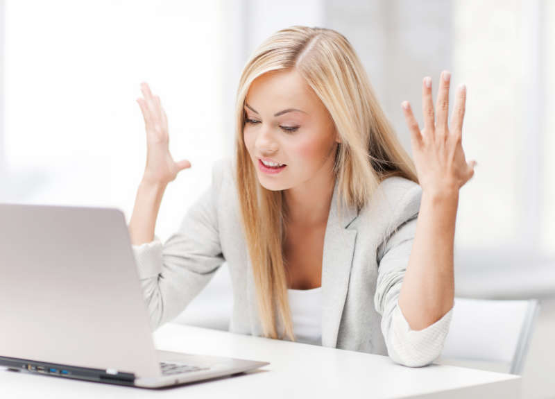 Blonde vrouw voor computer met een probleem