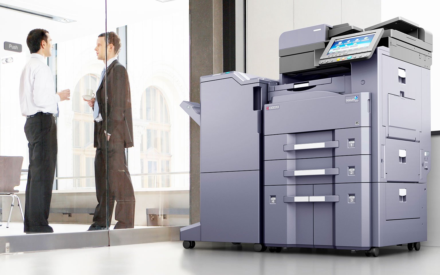 Printer met op de achtergrond twee medewerkers.