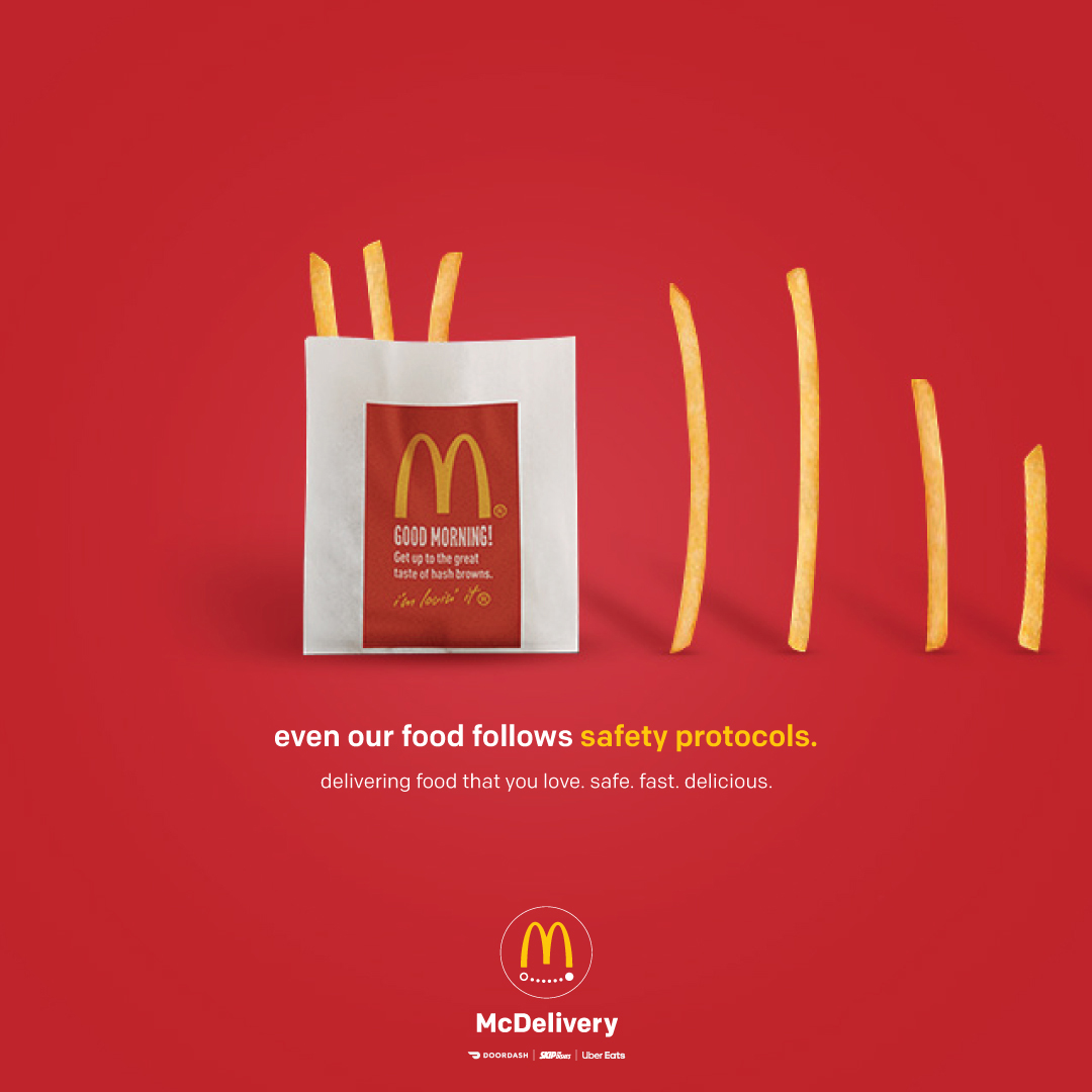 A McDonalds ad shows a red background with french-fries lining up to jump into the package but keeping social distance measures between them. The fries approach the package on the left from the rigth side of the ad. The copy reads "even our food follows protocals" "delivery food that you love. safe. fast. delicious." The logo appears at the bottom centre of the ad.