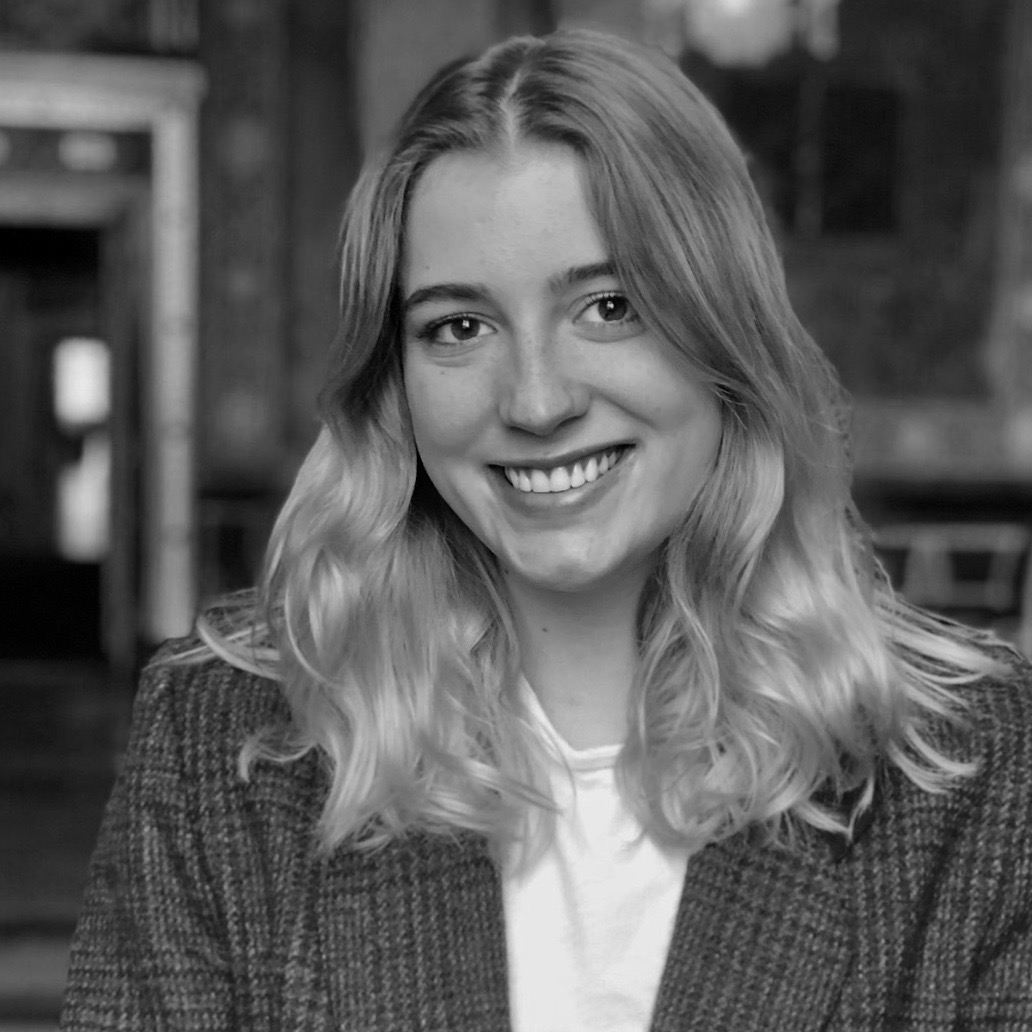 Female identifying person with long blond hair, smiling outside