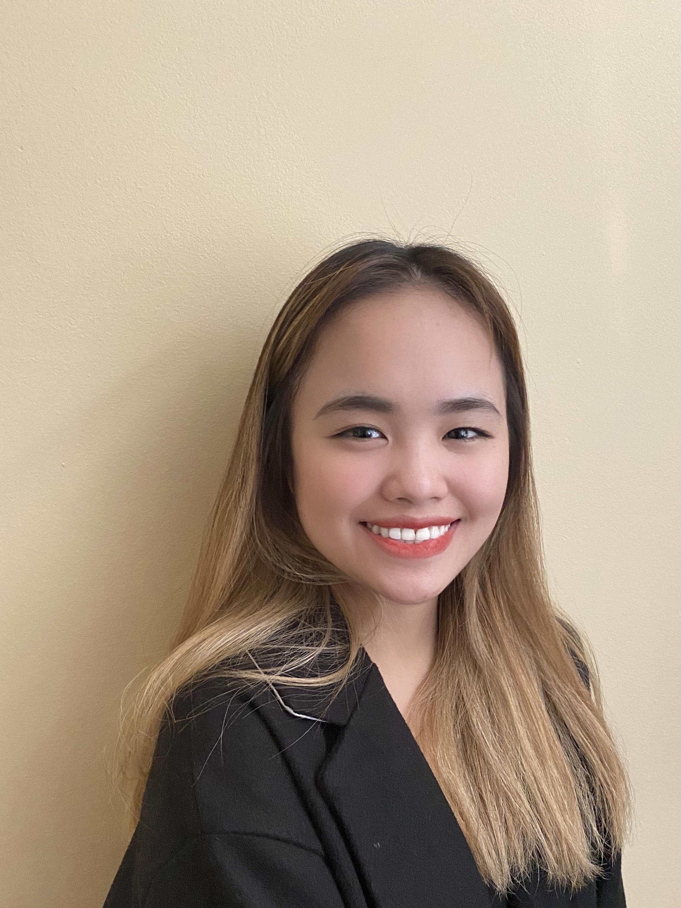 Picture of Anna smiling at the camera, wearing a black blazer