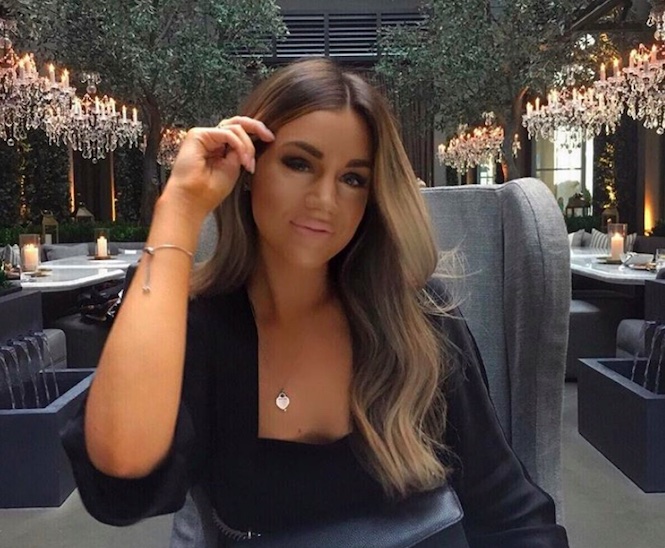 Picture of Carleigh, posing with a black long sleeve blouse