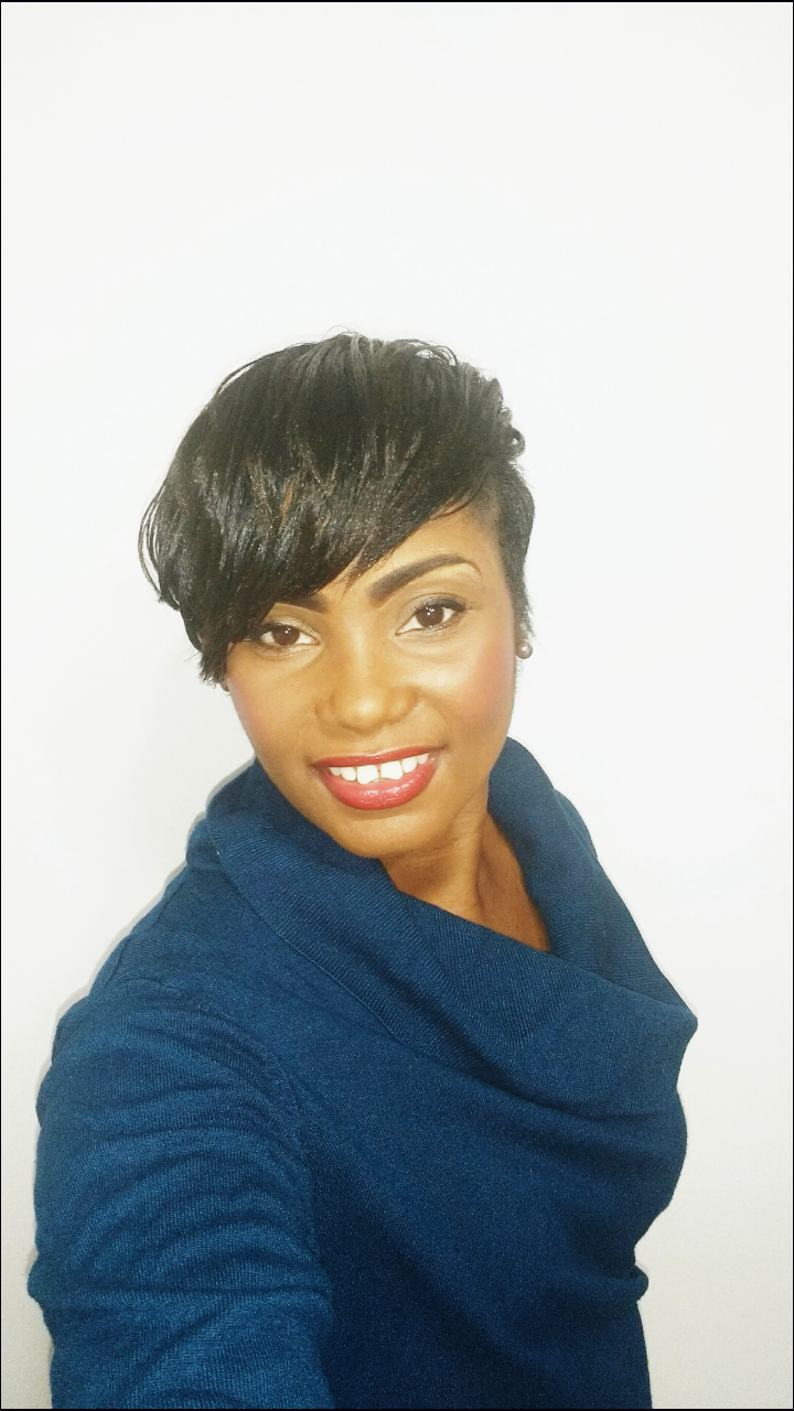 Portrait picture of Linelle, smiling and wearing a blue sweater