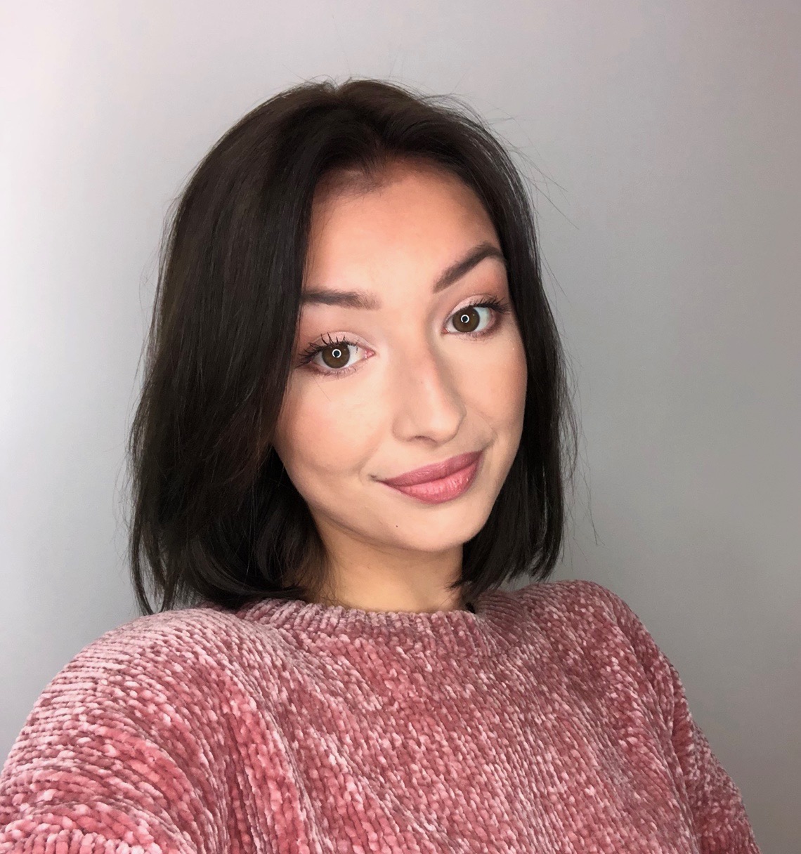 Portrait picture of Savannah, smiling and wearing a light red sweater