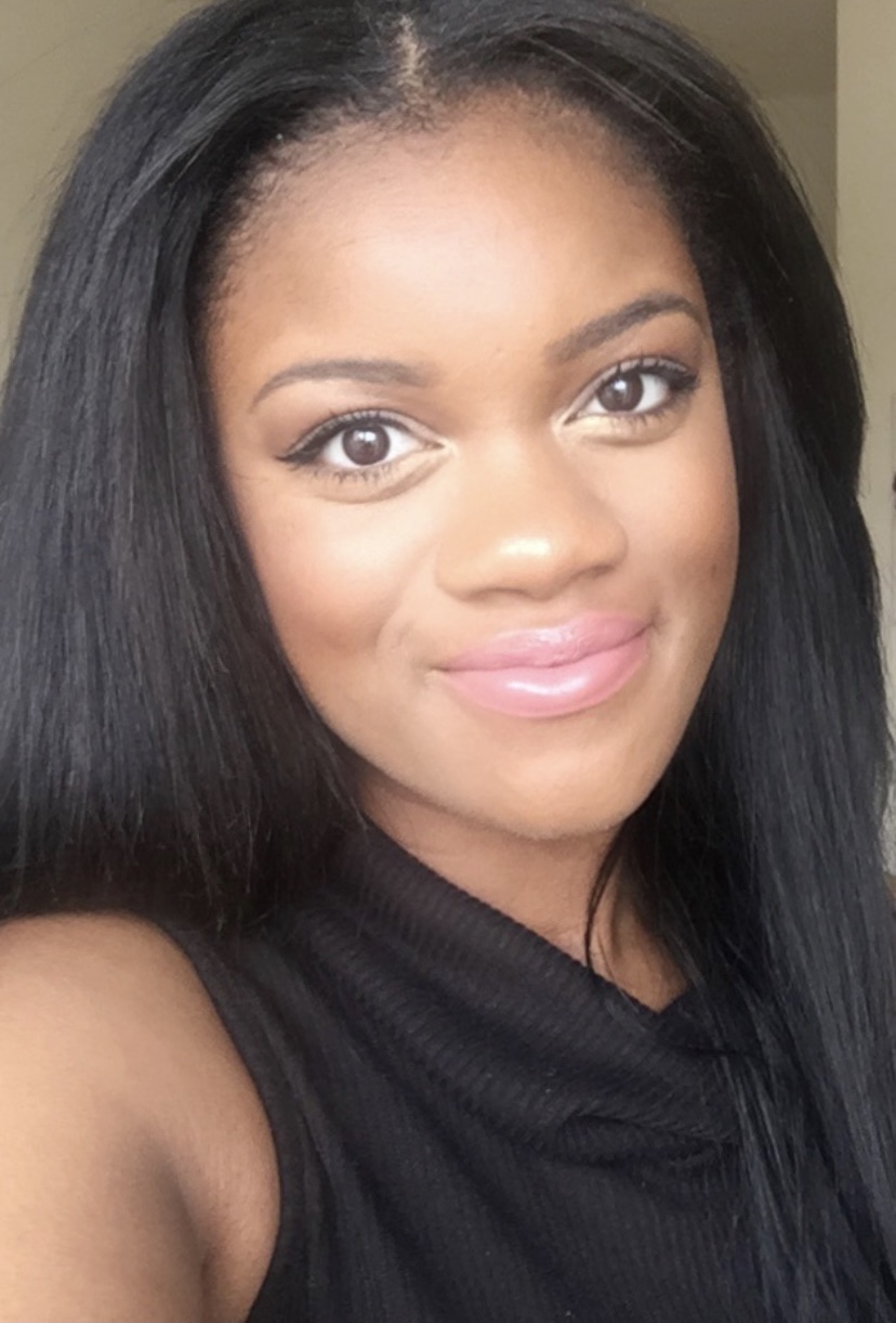 Picture of Yanisha, smiling and wearing a turtle neck black shirt.