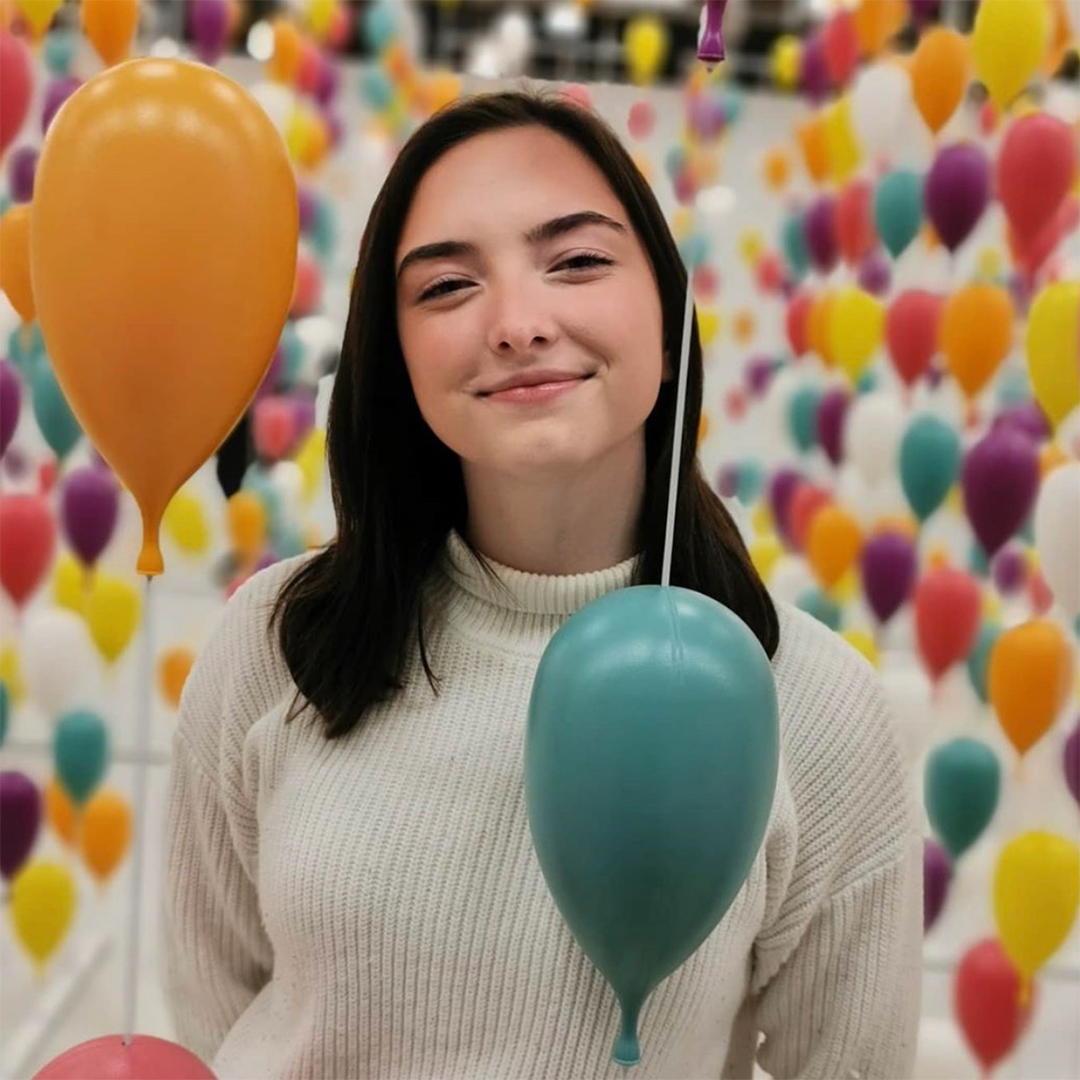 Image of Mallory with balloons in the background.