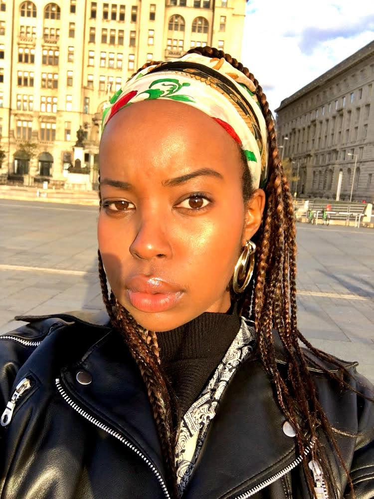 Ndenzi is standing outside, behind her are old European buildings.