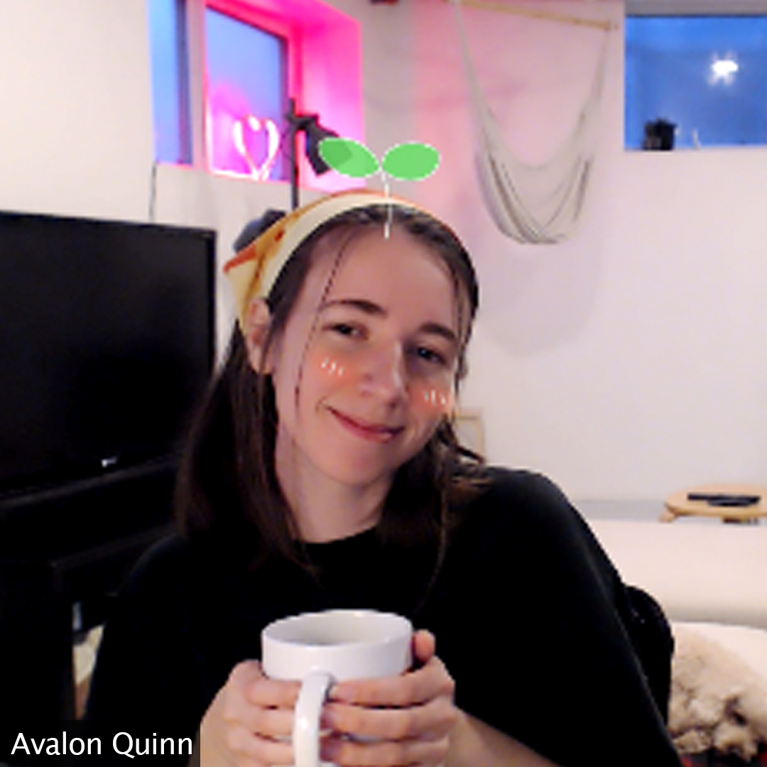 Picture of Avalon smiling at the camera with a dog hidden in the corner