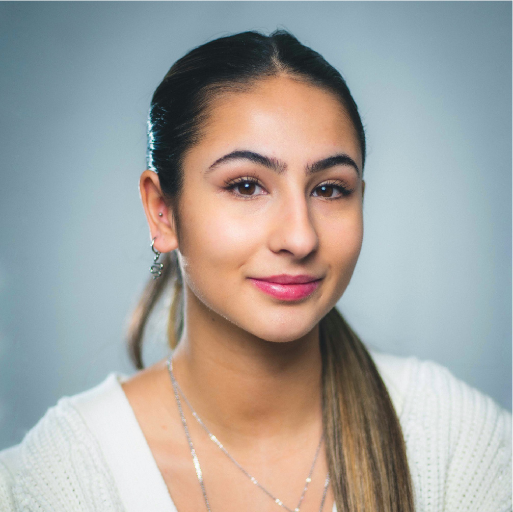 Headshot of Ana Rodrigues, wearing a white sweater