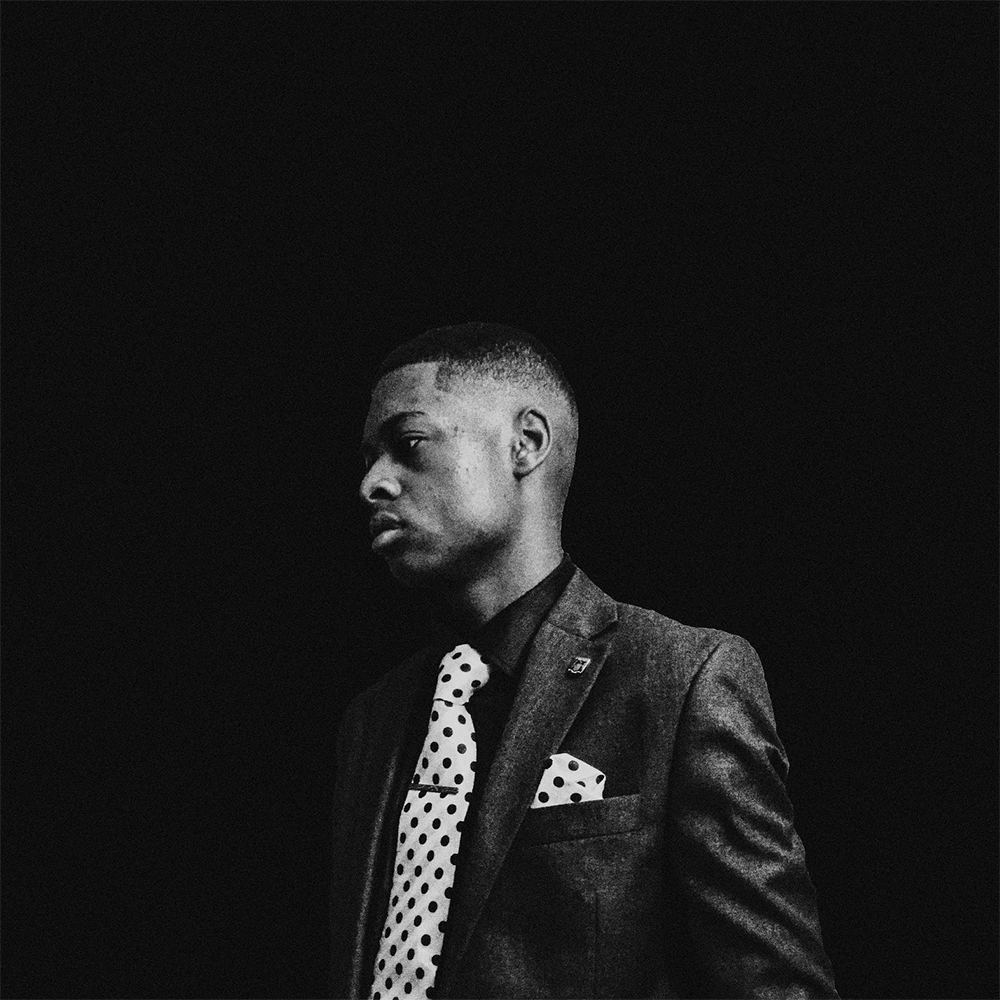 Black and white picture of Andrew, wearing a shirt with a tie.