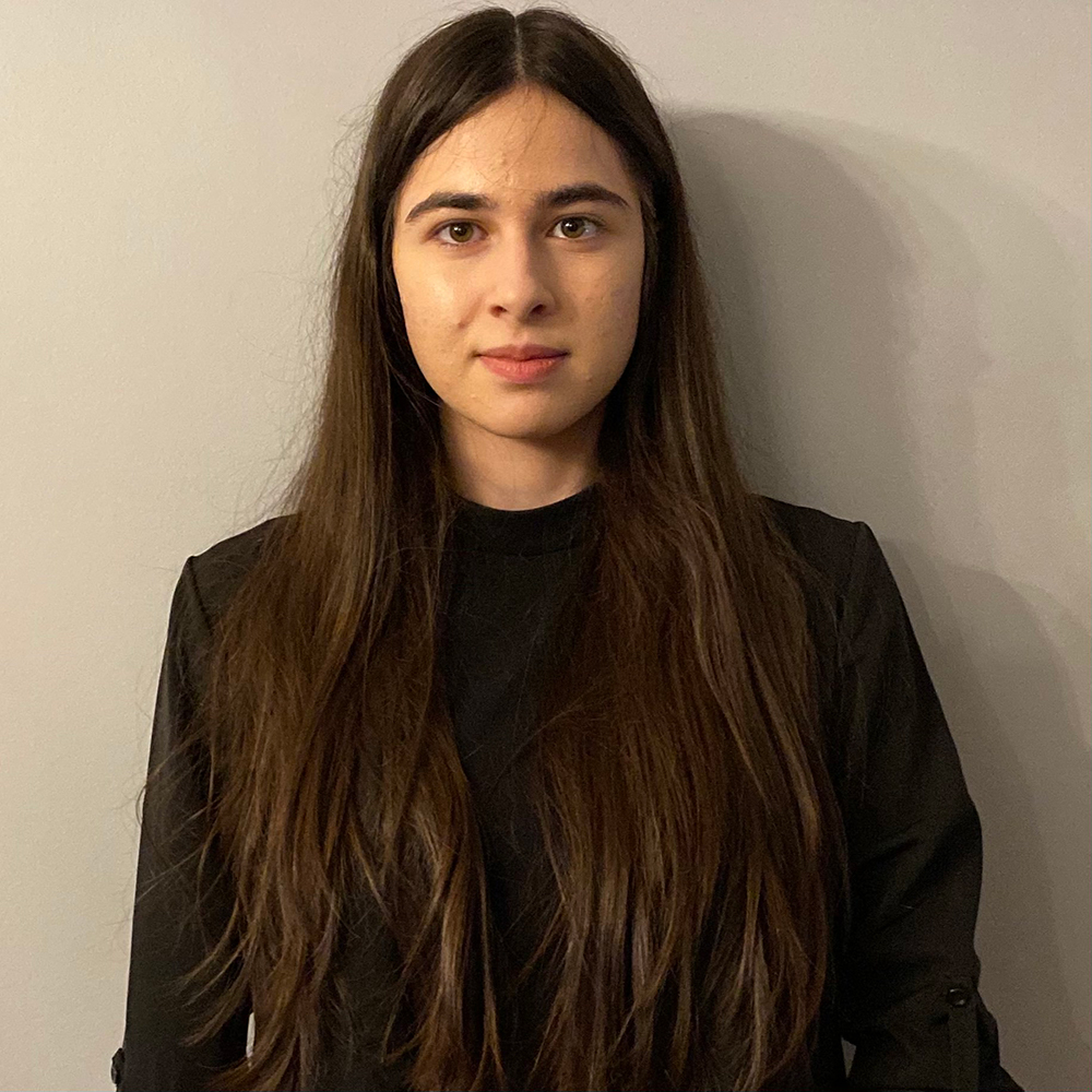 Picture of Bella posing for the camera wearing a black blouse