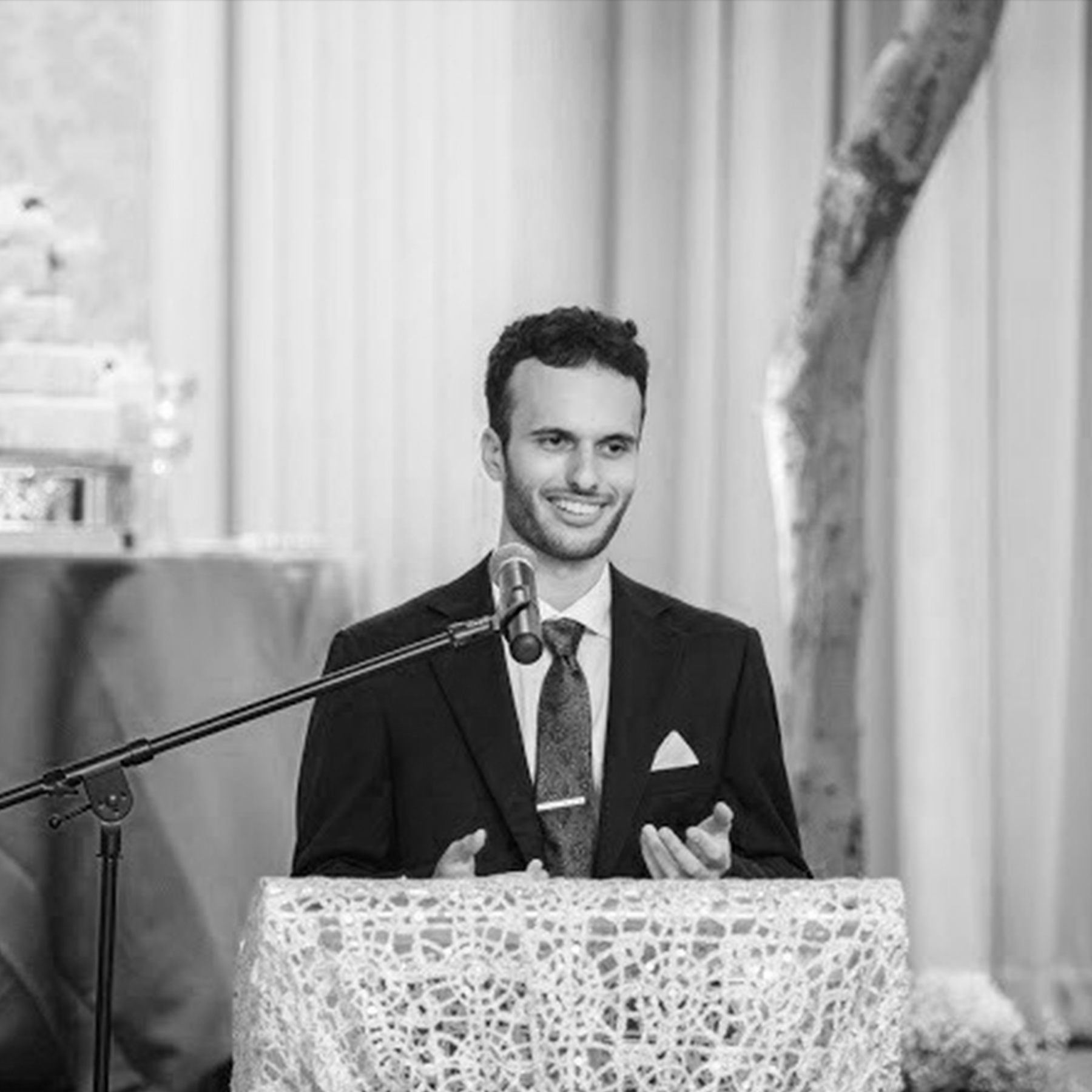 Dusan Mandic wearing a suit giving a speech