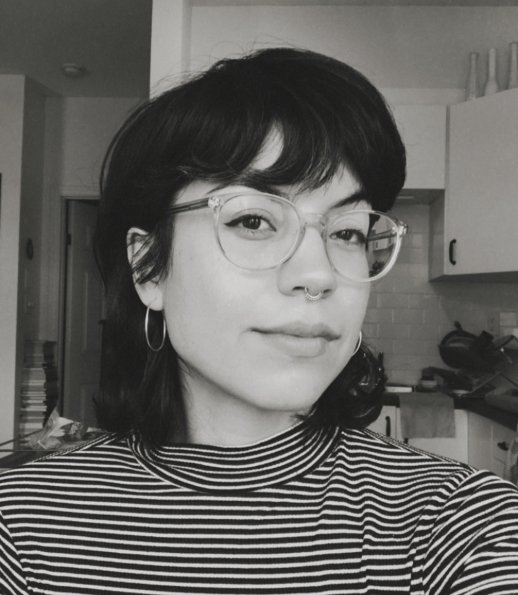 Black and white photo of a woman with short, dark hair, and glasses.