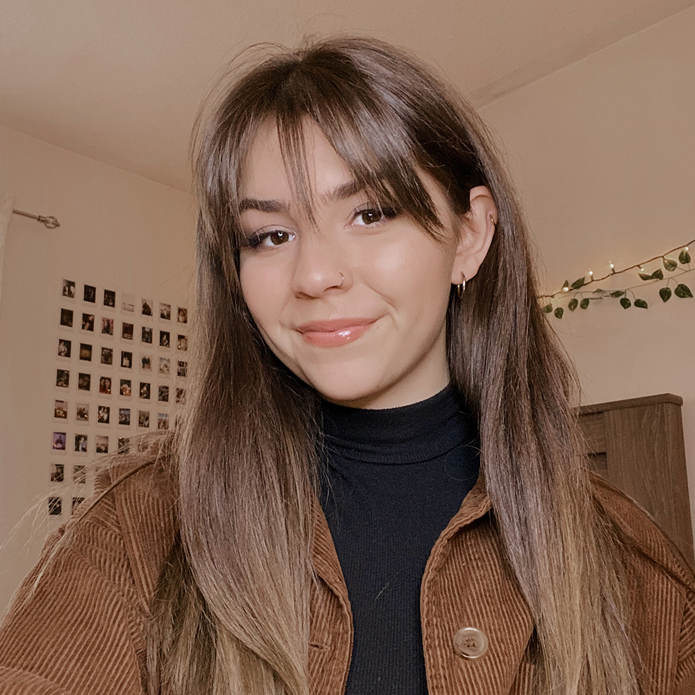 Picture of Jessica, wearing a honey-brown jacket with a turtle neck black shirt