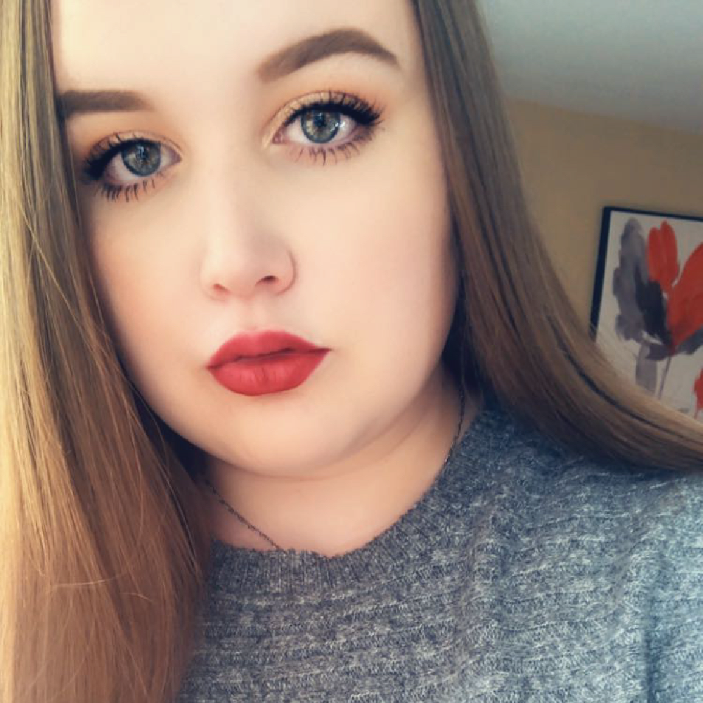 Picture of Megan, wearing a grey shirt and red lipstick