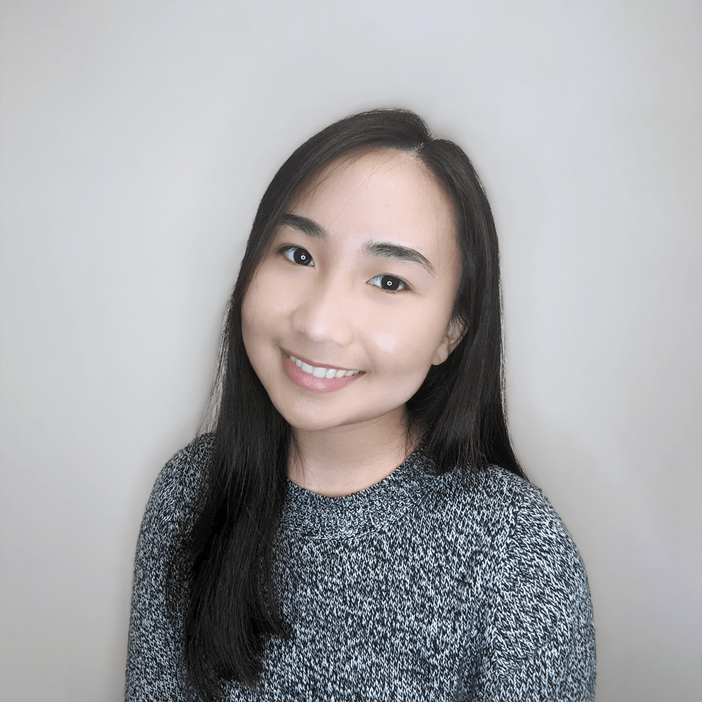 Picture of Nizea, smiling to the camera and wearing a grey sweater