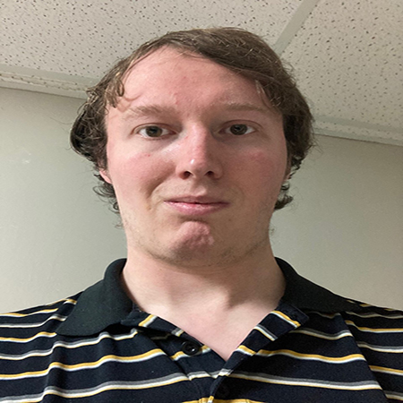 A headshot of John Vigneau. They are in a black striped shirt in front of a wall.