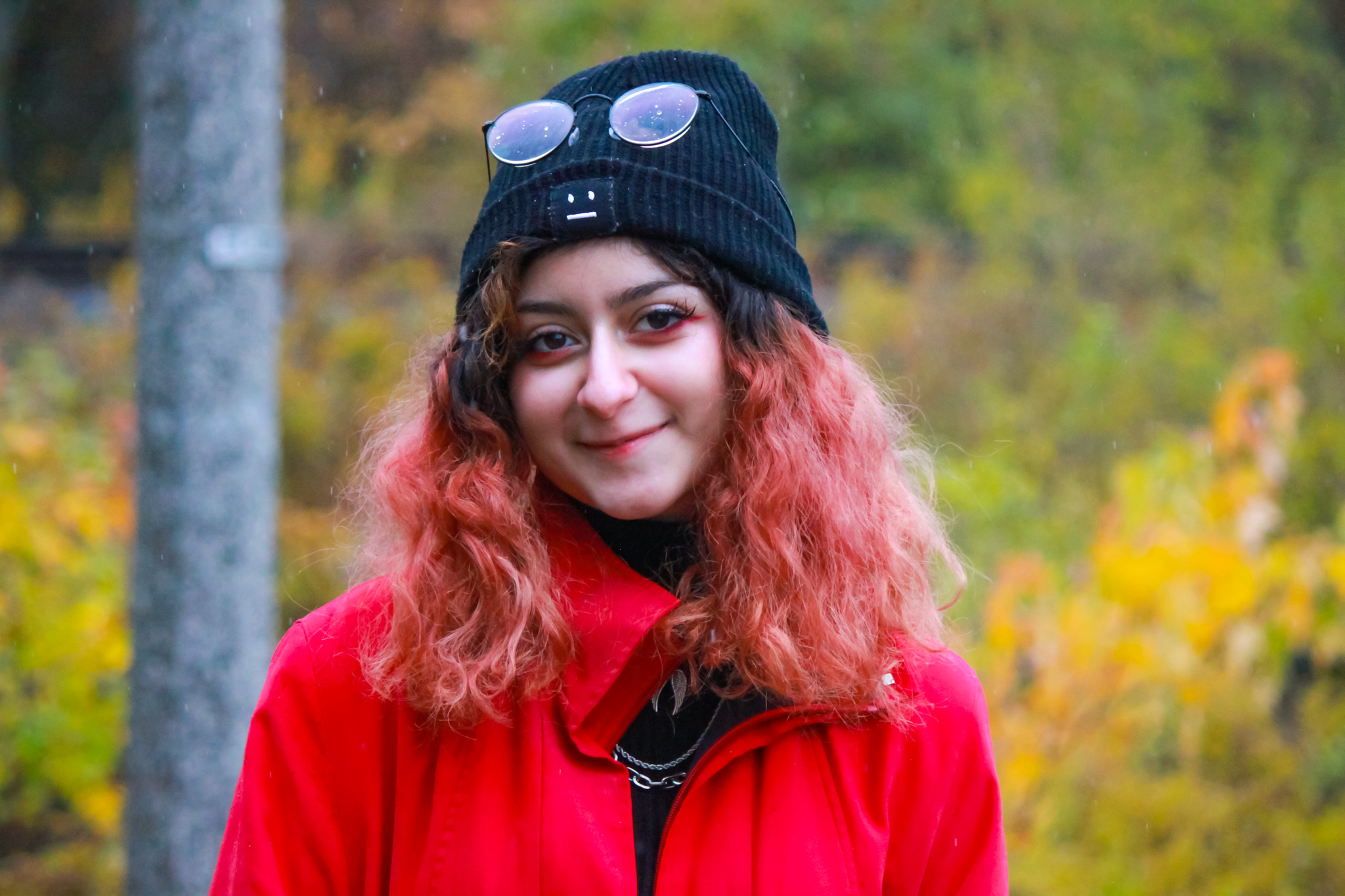 Picture of Negeen outside, wearing a red sweater and black gap