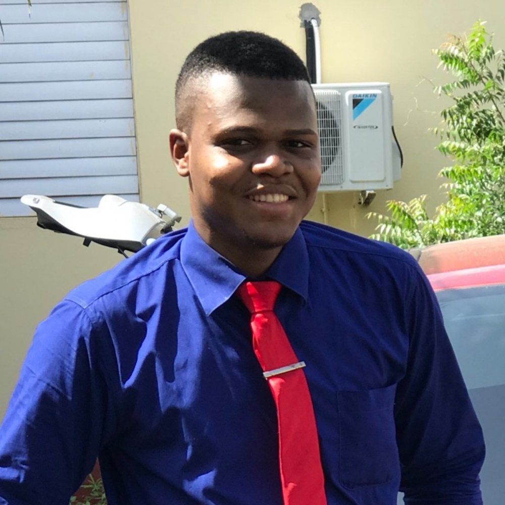 Picture of Stephaun outdoors, wearing a blue shirt with a red tie