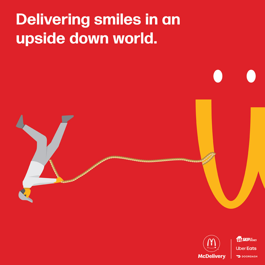 A McDonalds ad shows a red background with upside down golden arches. A drawing of a small figure pulls the arches with a rope. Two dots above the arches resmble eyes. In white type at top it says "Delivering smiles in an upside down world." The McDelivery logo, Skip the Dishes, UberEats and Doordash logos in white at the bottom right corner.