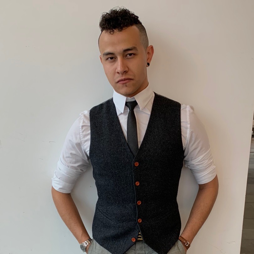 Picture of Ethan, wearing a black vest, white shirt and black tie