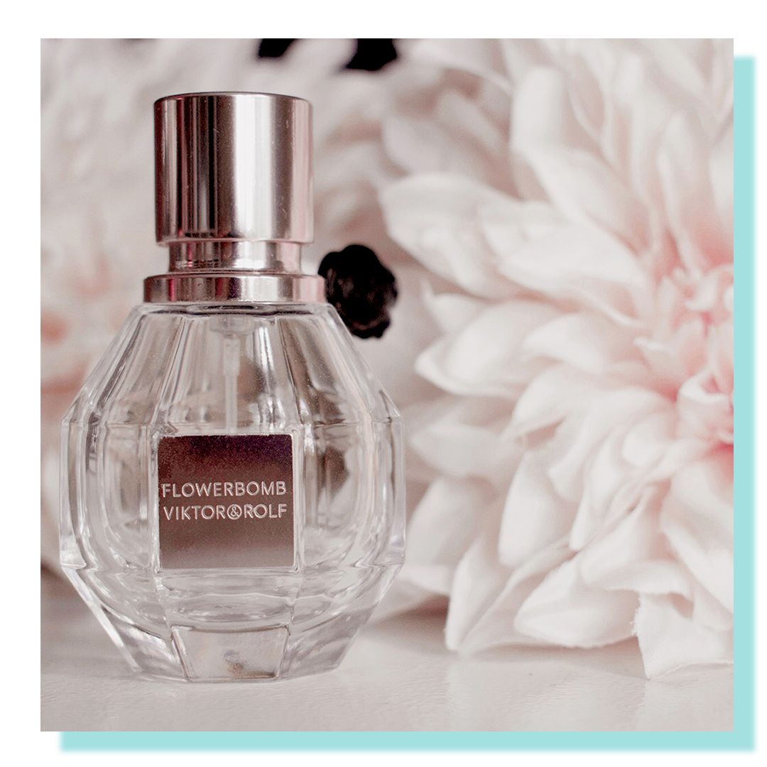 Small clear bottle with soft pink flowers behind