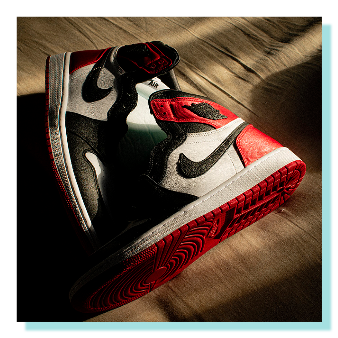 A pair of Nike running shoes on a black background lit with dramatic theatrical lighting