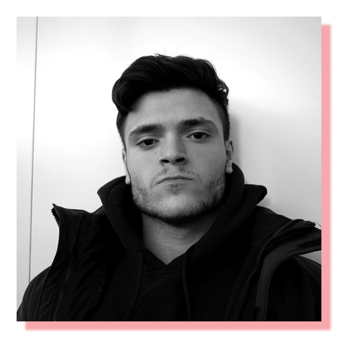 Black & white head shot portrait of a 20 year old man with a stern look on his face.