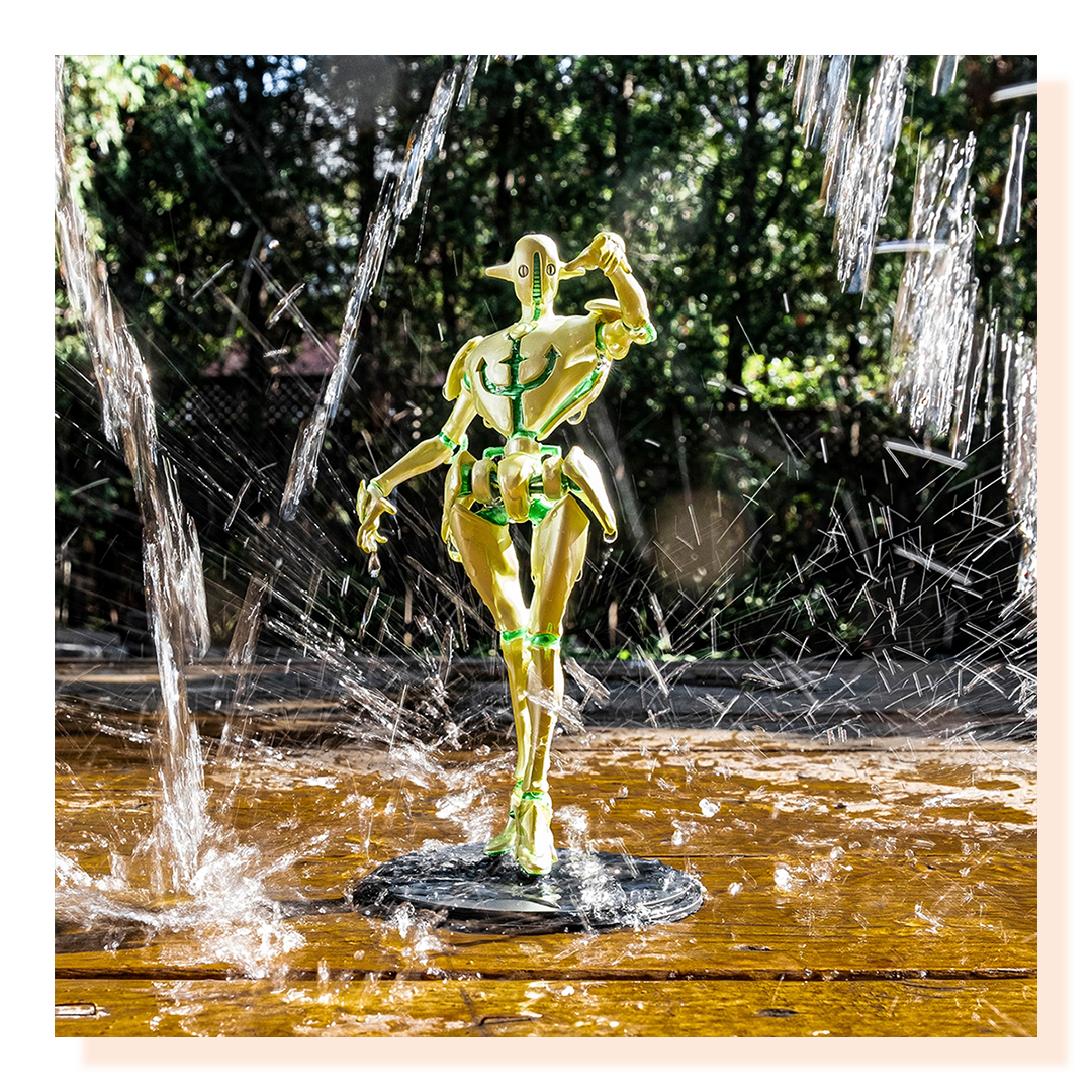 Statue in water posing while water is falling around it.