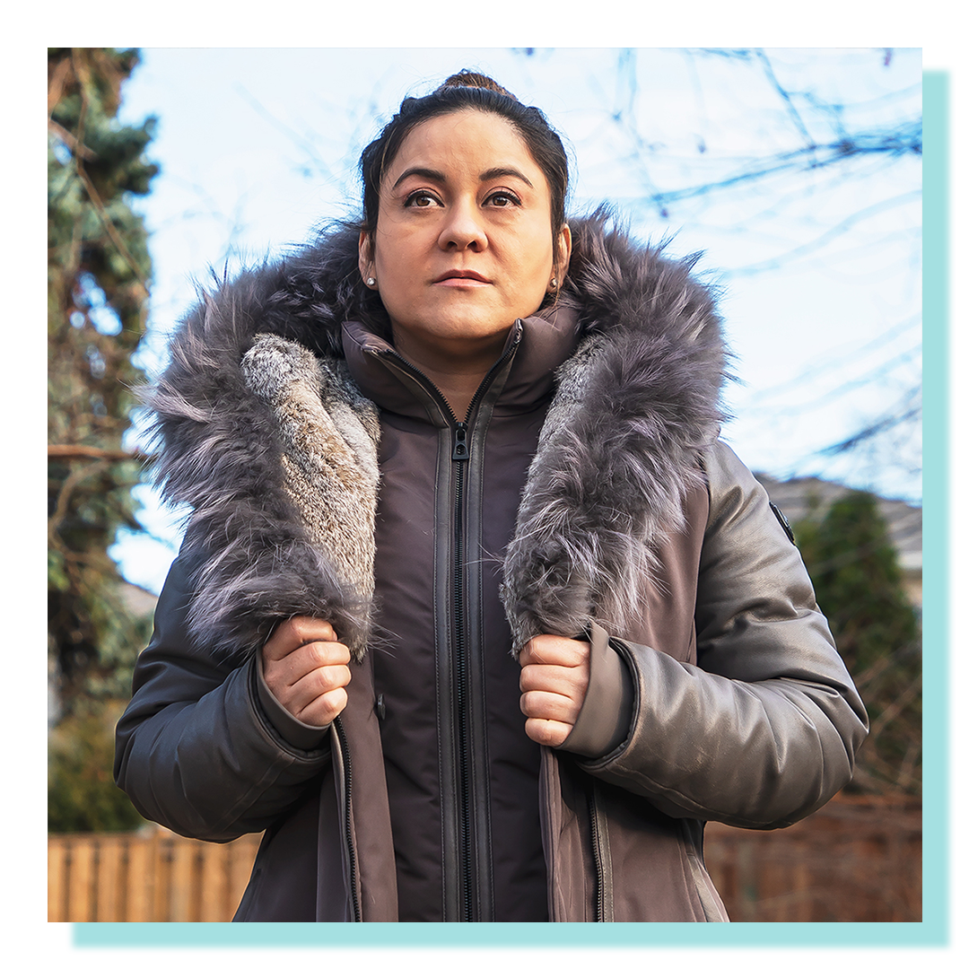 A women in her 30’s wearing a winter parka looking slightly off camera angle.