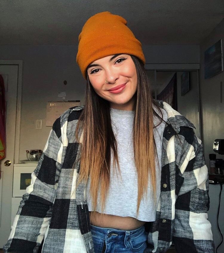 Young woman in plaid shirt and orange beanie hat
