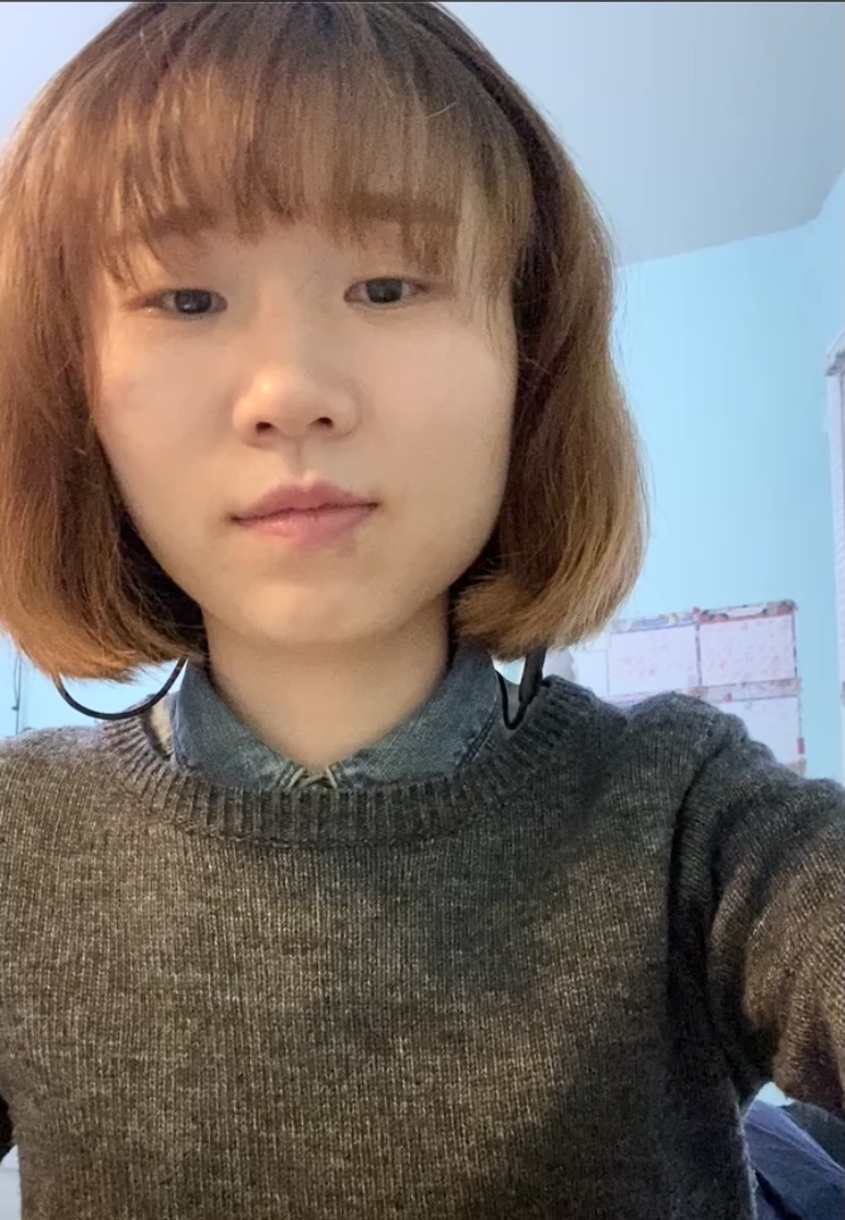 Young woman in grey sweater smiling