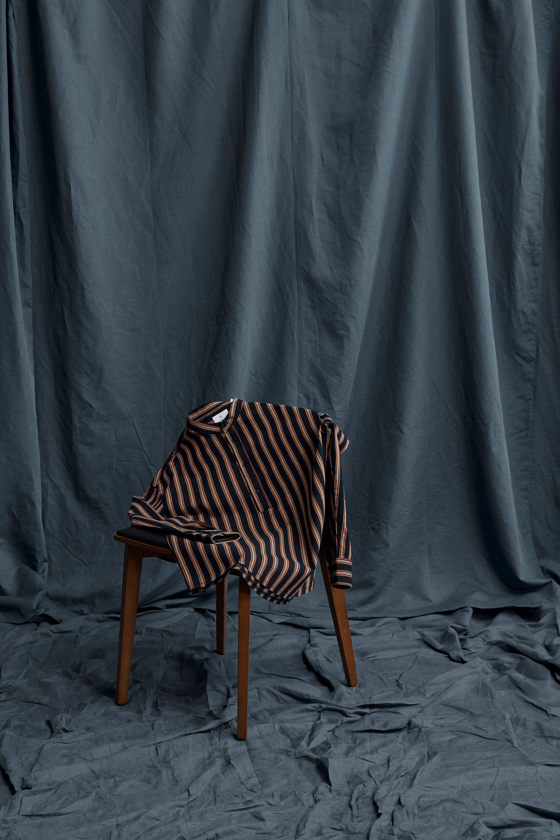 The Henley Shirt laid effortlessly on top of a chair in the studio.
