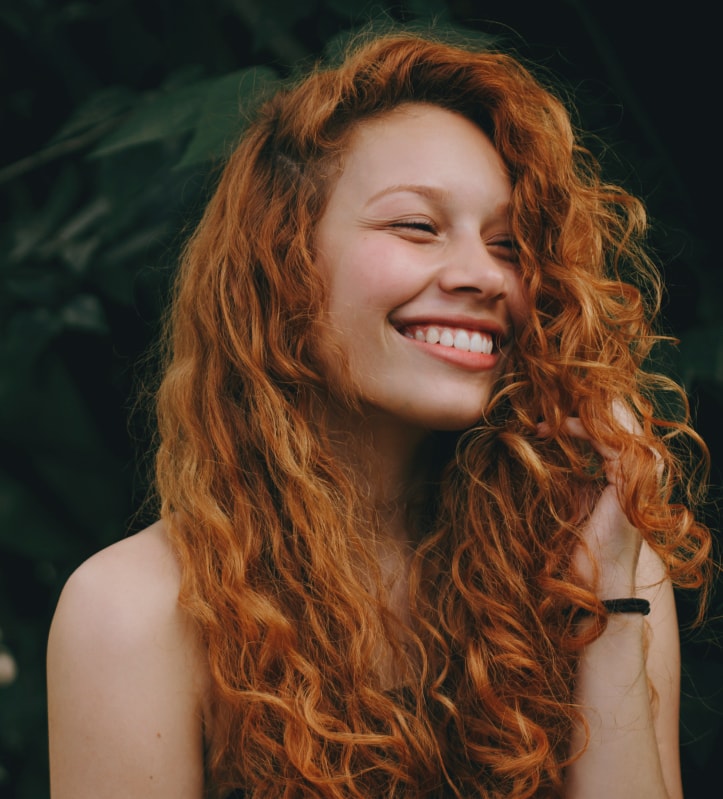 Beaming woman looking over her shoulder.