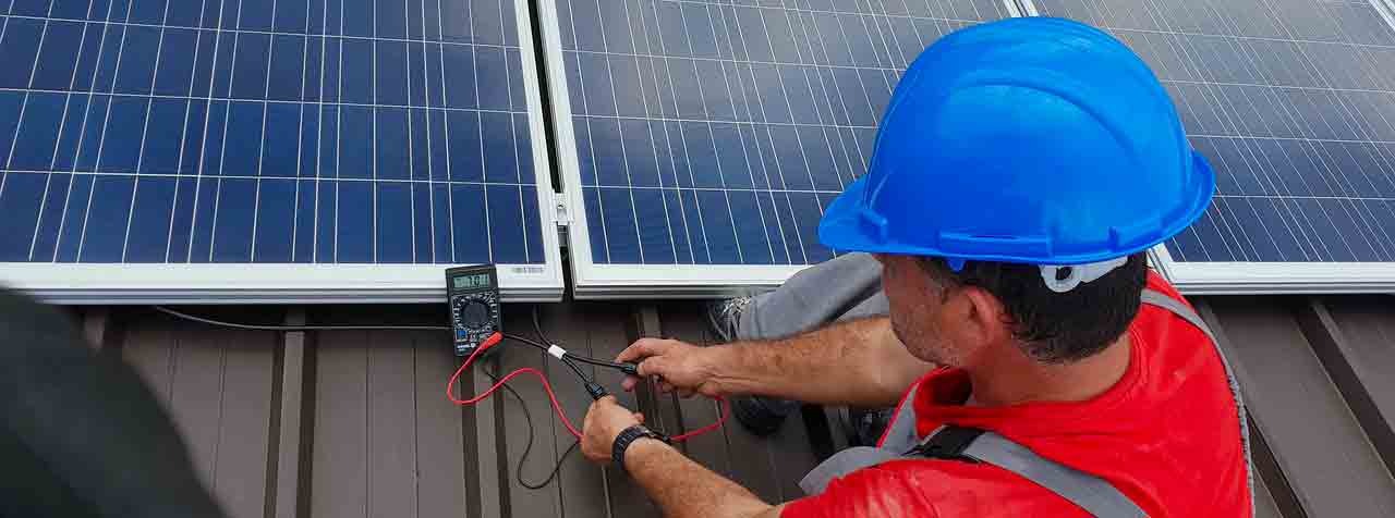 Technicien photovoltaïque réalisant un diagnostic de panne sur une centrale solaire.