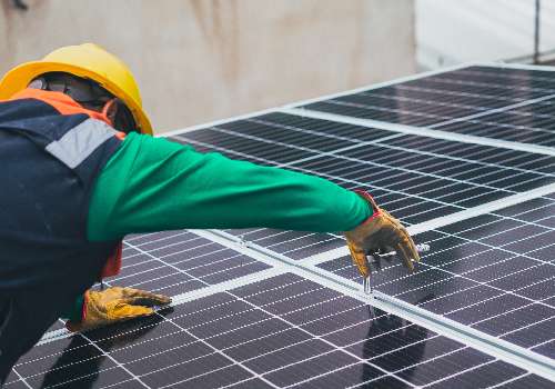 Installateur de panneau solaire vérifiant une installation pour valider le Consuel.