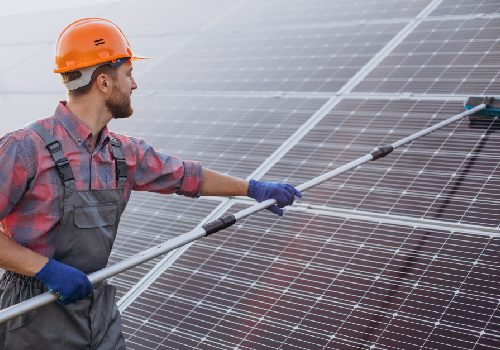 installateur nettoyant des panneaux solaires pour leur maintenance