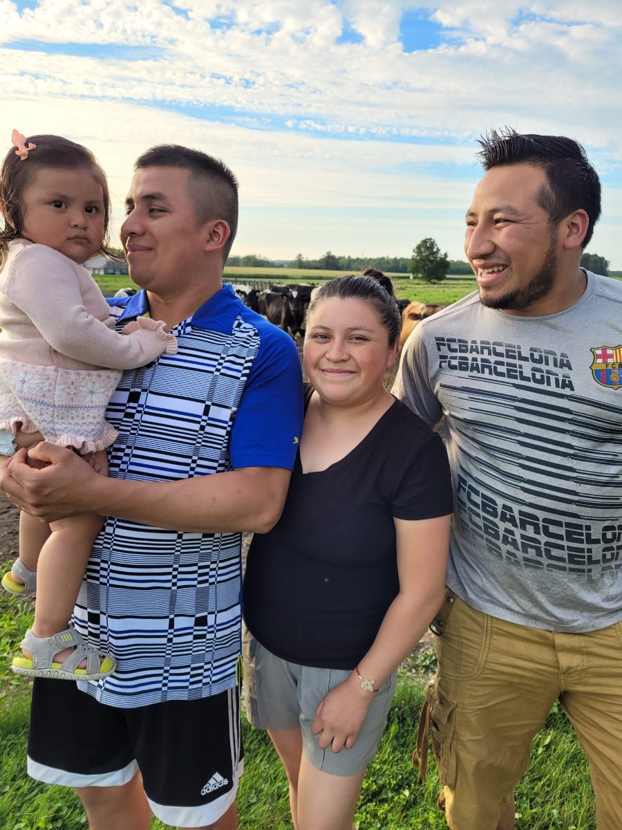 At right, Efrain, with his brother Ervin (at left), who works at the same dairy. Also pictured are Ervin's wife and daughter.