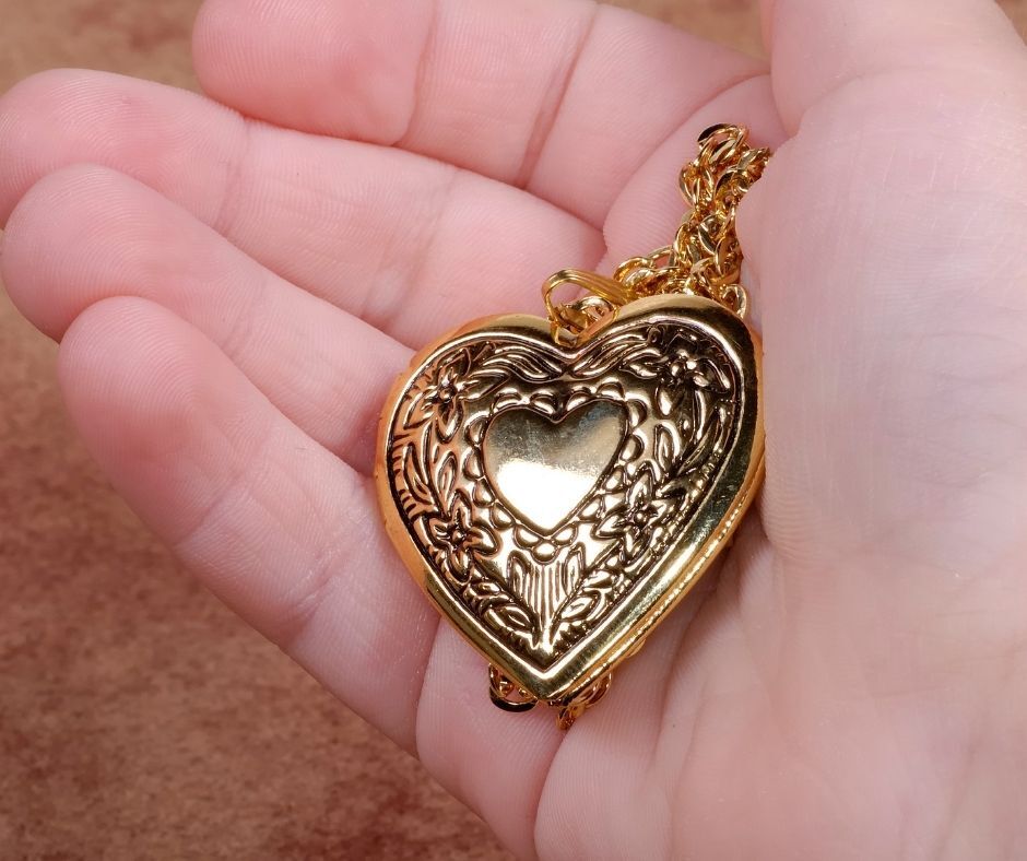 child holding a jewelry locket necklace
