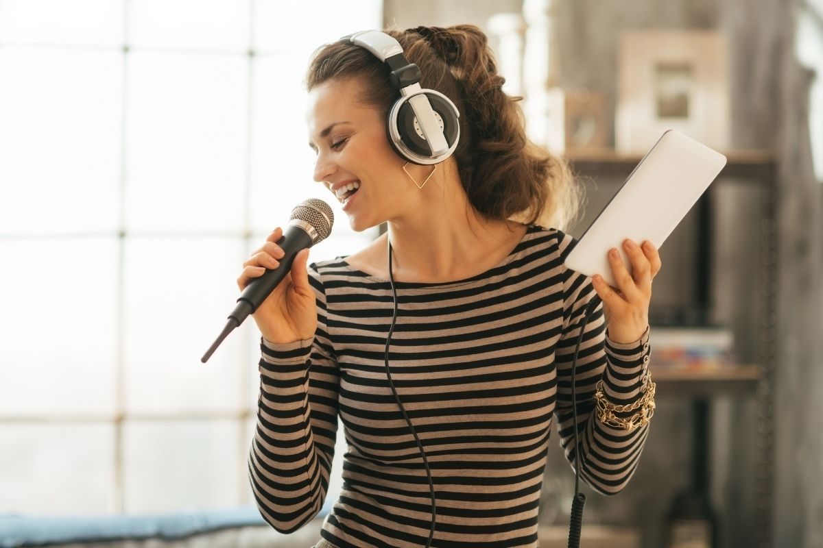 woman singing into microphone holding phone