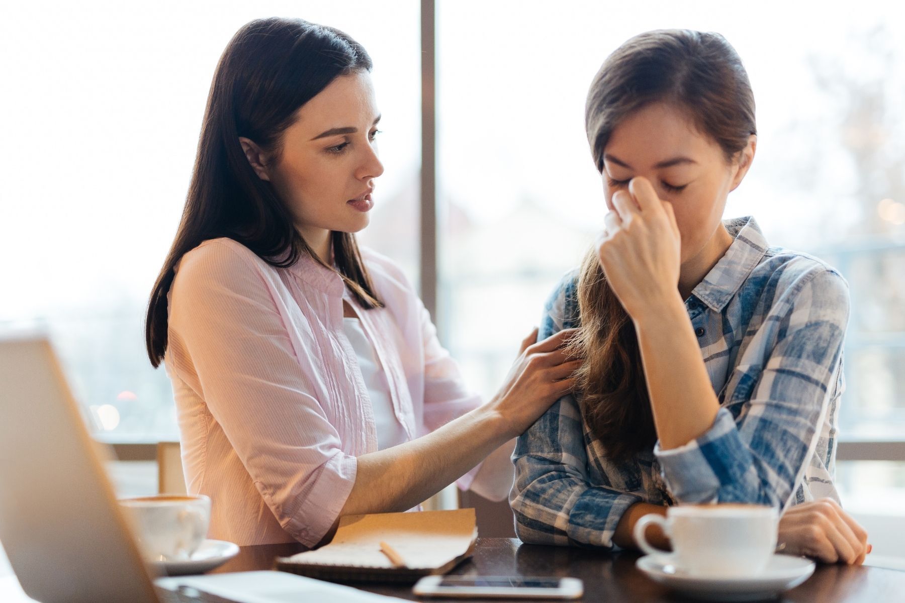 one woman consoling another