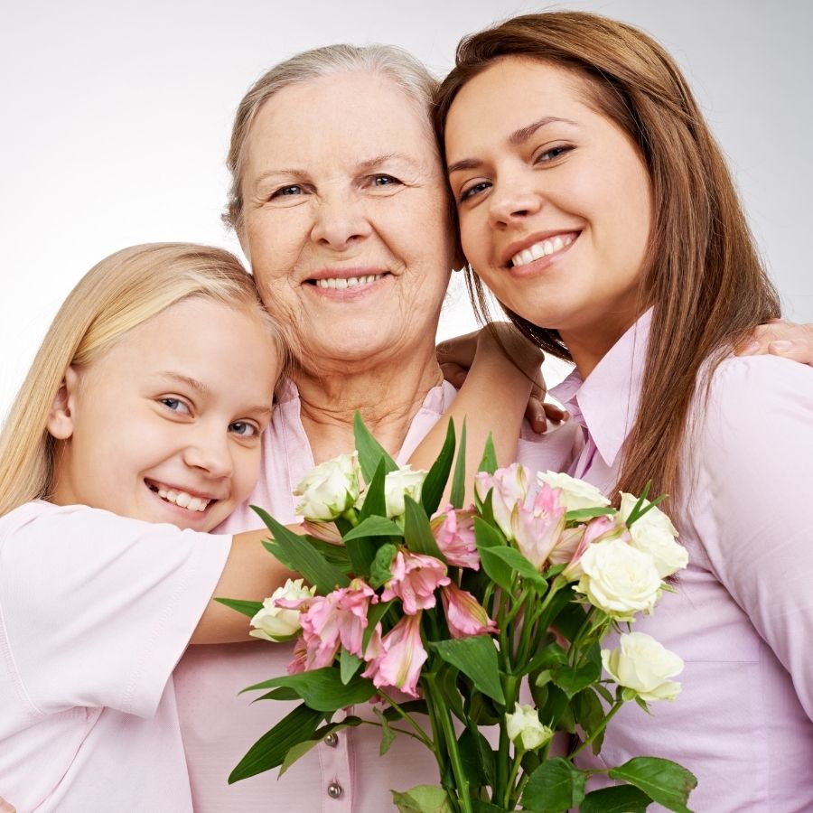 Mom and daughter hugging grandma.