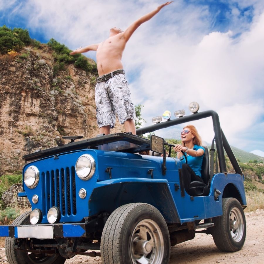 Couple enjoying sun in a Jeep