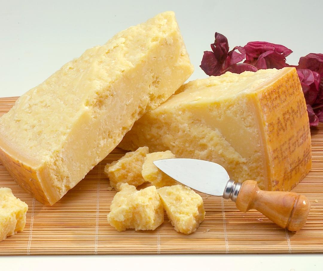 Parmesean Reggiano on a cutting board with a cheese knife