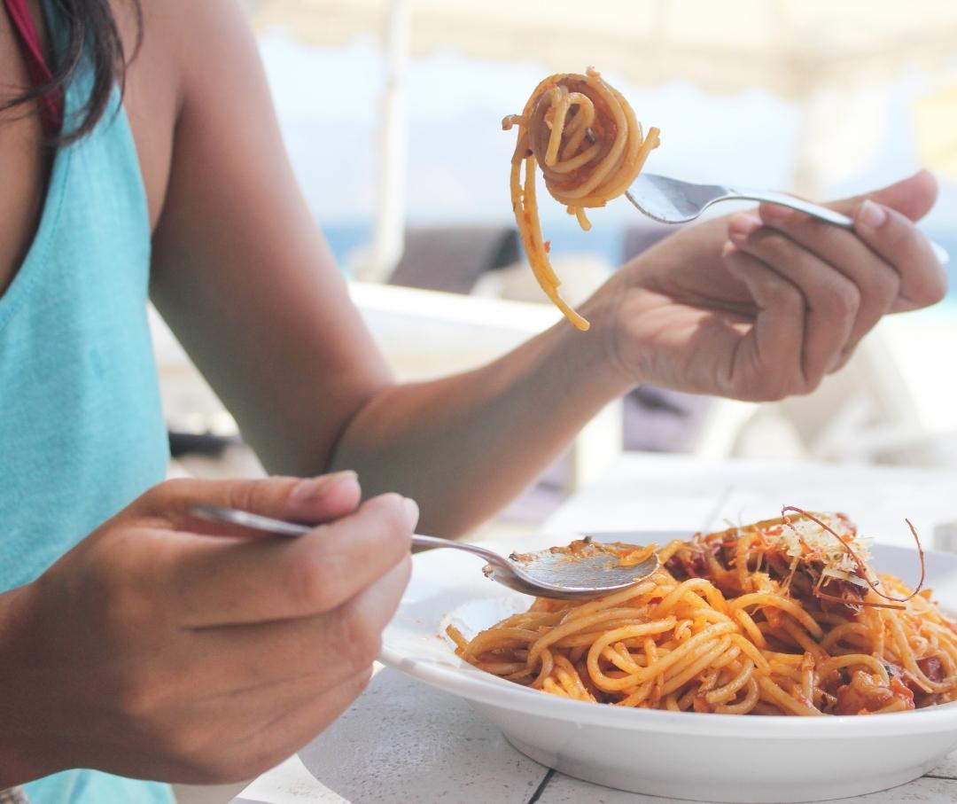 woman eating a plate of pasta