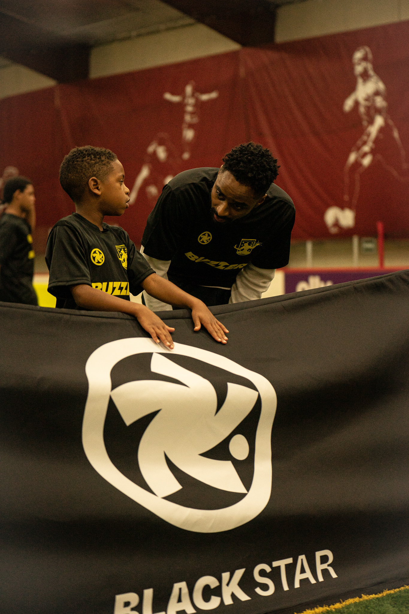 Soccer coach and young player spotted during Black Star Initiative talking during the event.