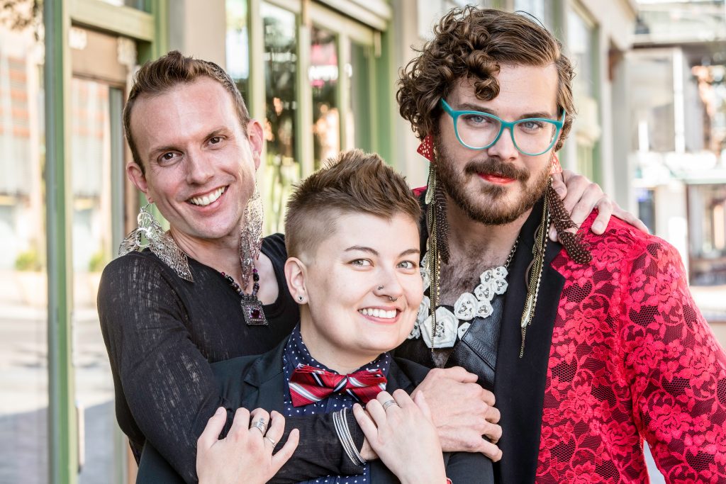 Three loving friends or a happy triad of non-binary folks hugging.